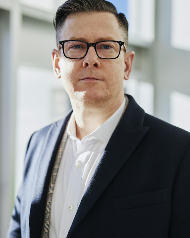 A stylist with a short cut, used as a sample portrait for men's cuts